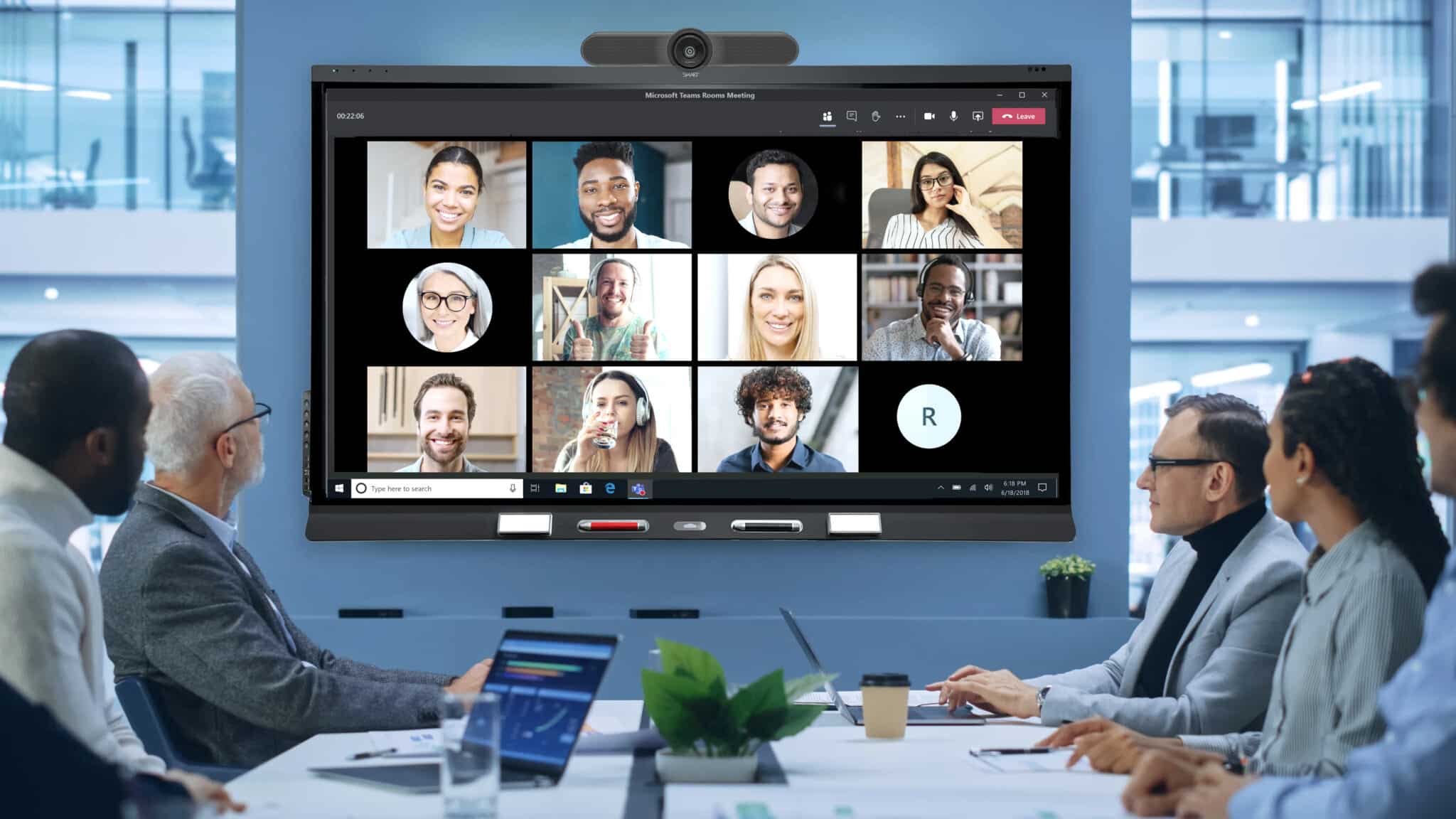 Een afbeelding van een team in een videovergadering met hybride medewerkers in een vergaderruimte / teams room.