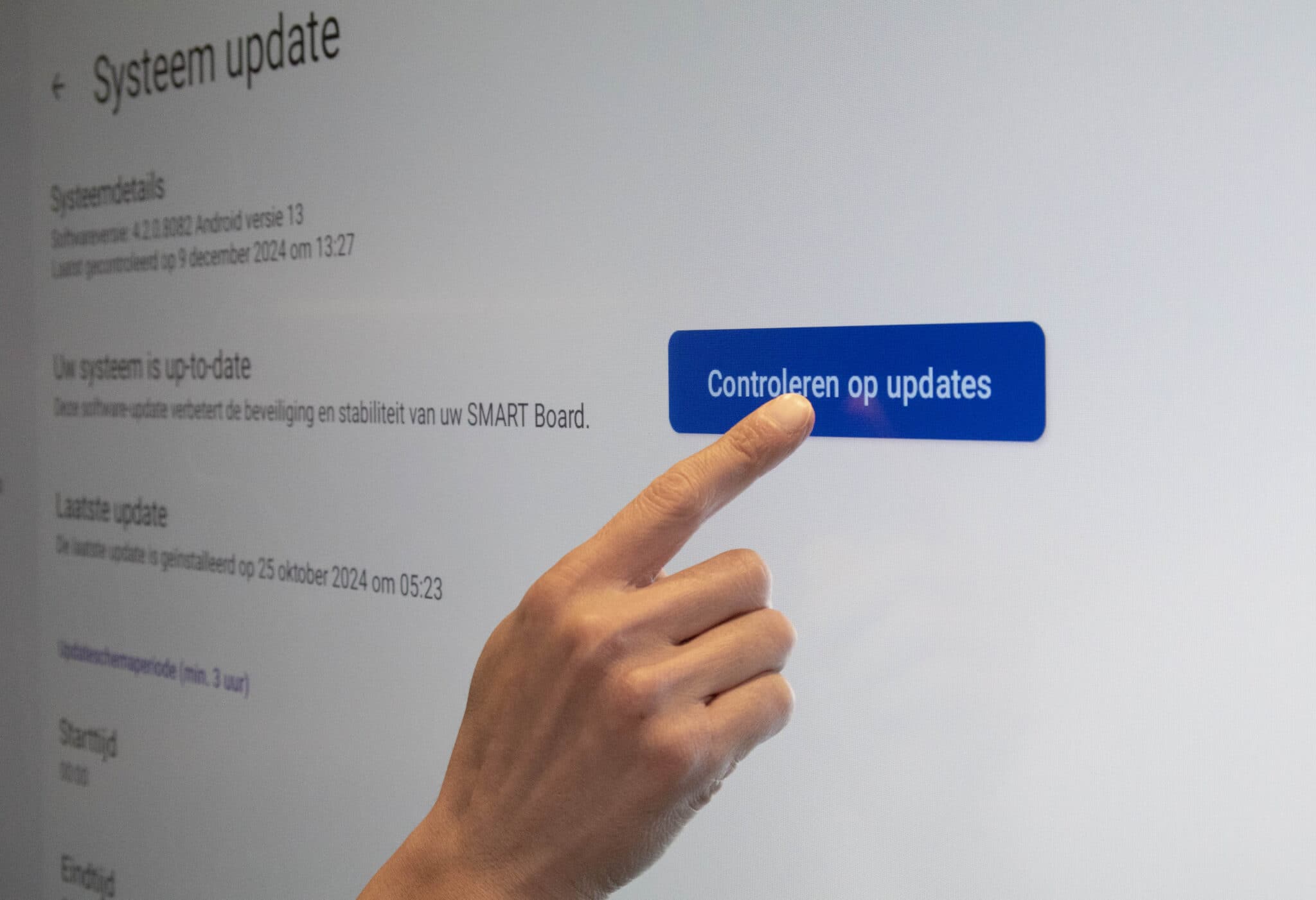Afbeelding waarin een persoon klikt op de controleren op updates knop in een SMART Board.