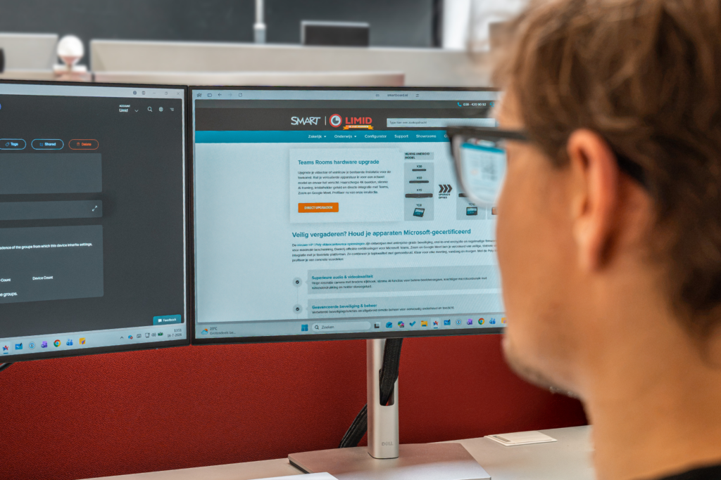Medewerker werkt achter twee monitoren met smartboard.nl website