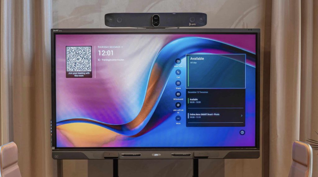 Interactief scherm, een SMART Board QX Pro, met daarboven een Poly videobar gemonteerd in een vergaderruimte.