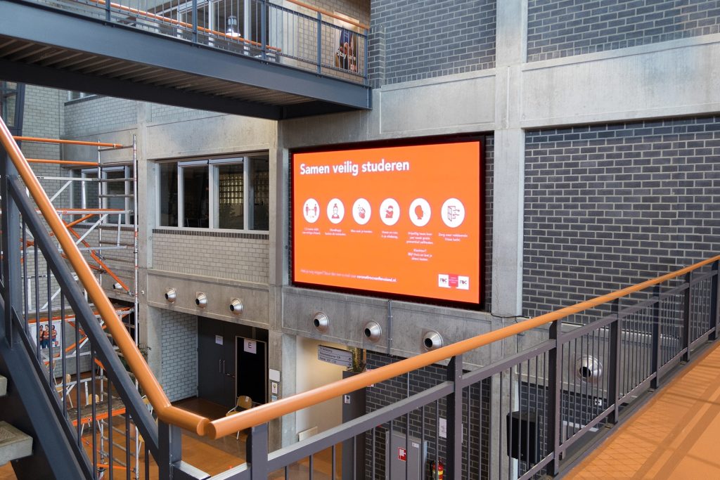 Mooie afbeelding van een geplaatst indoor LED scherm op een school in Lelystad. De foto is genomen vanaf de trap en is goed zichtbaar voor studenten.