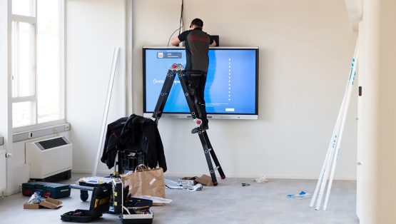 Een afbeelding van Limid installateur die een SMART Board installeert.