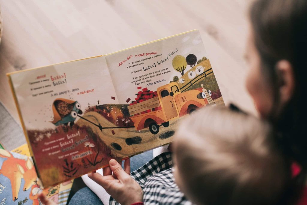 Iemand leest een boek aan iemand voor en maakt gebruik van storytelling
