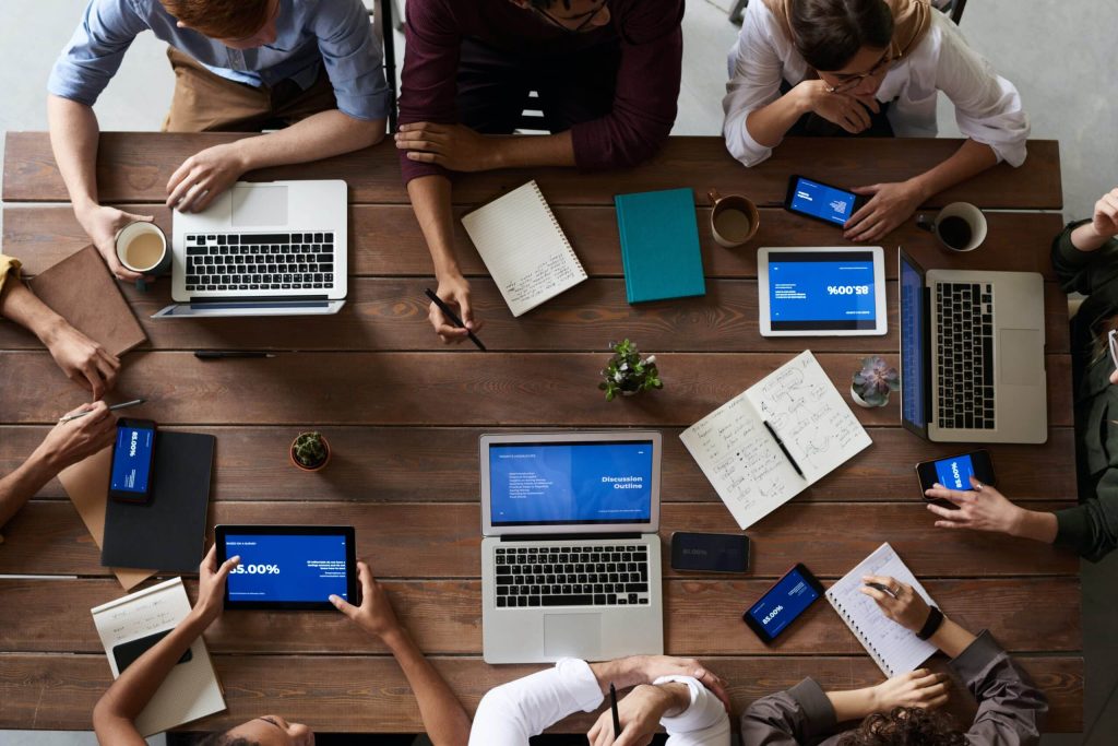 Verbonden brainstorm meeting meerdere mensen met laptops en notepads
