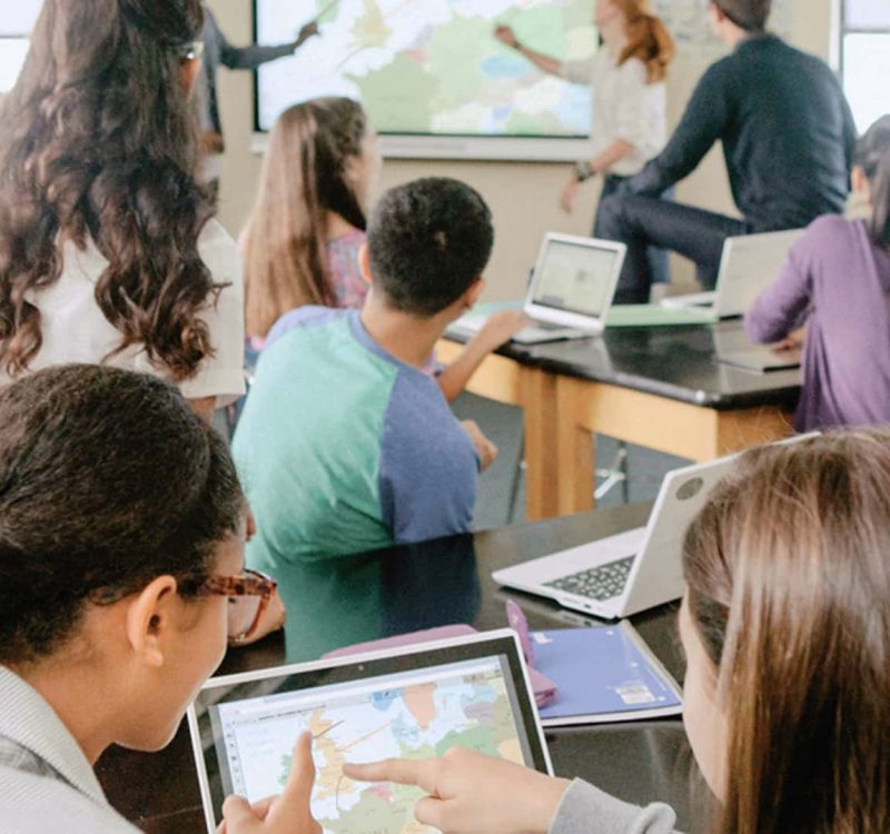 Een grote groep mensen maakt tegelijkertijd gebruik van SMART Learning Suite software op school. Ze zitten samen in de klas.
