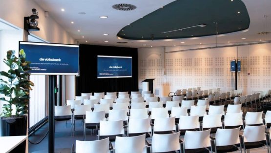 Een auditorium mooi ingevuld bij de Volksbank, met een focus op videovergaderen.